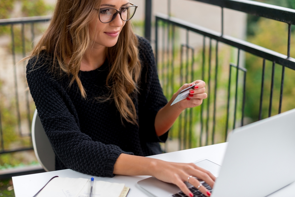 Woman wearing Glasses on laptop with credit card