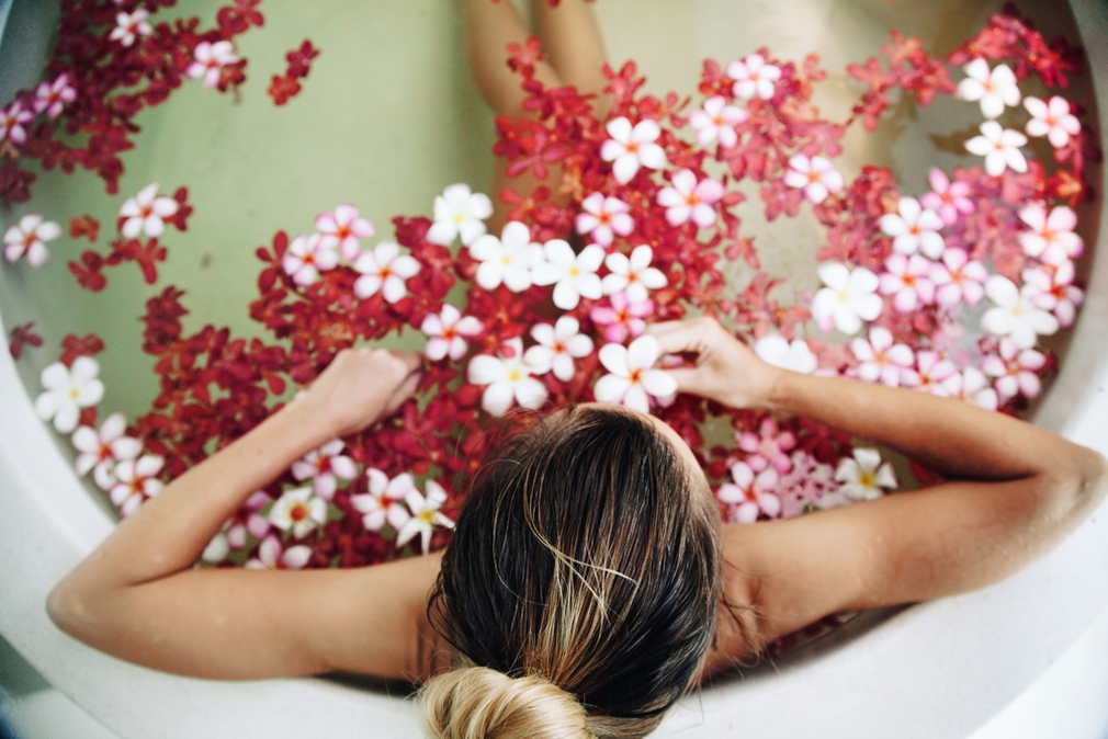Woman soaking in a bath of flowers